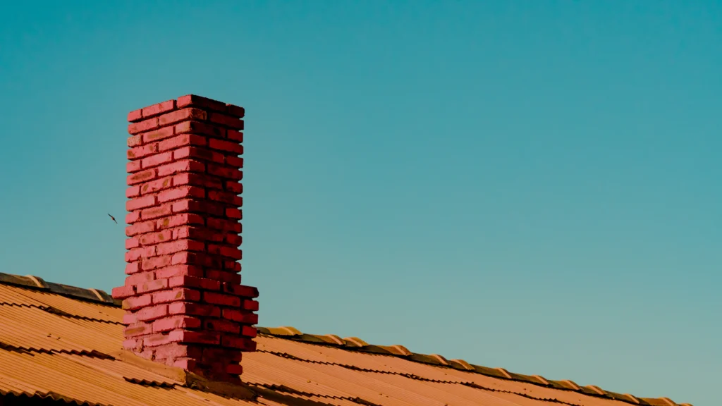 Red brick chimney rising above a roofline