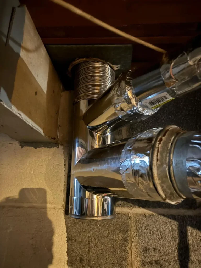 Close view of a liner fitting and connected vent pipes in Flemington