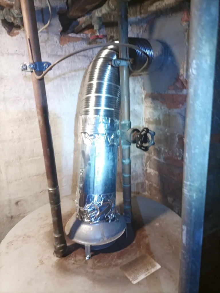 Basement appliance vent connection at the chimney wall in Millville