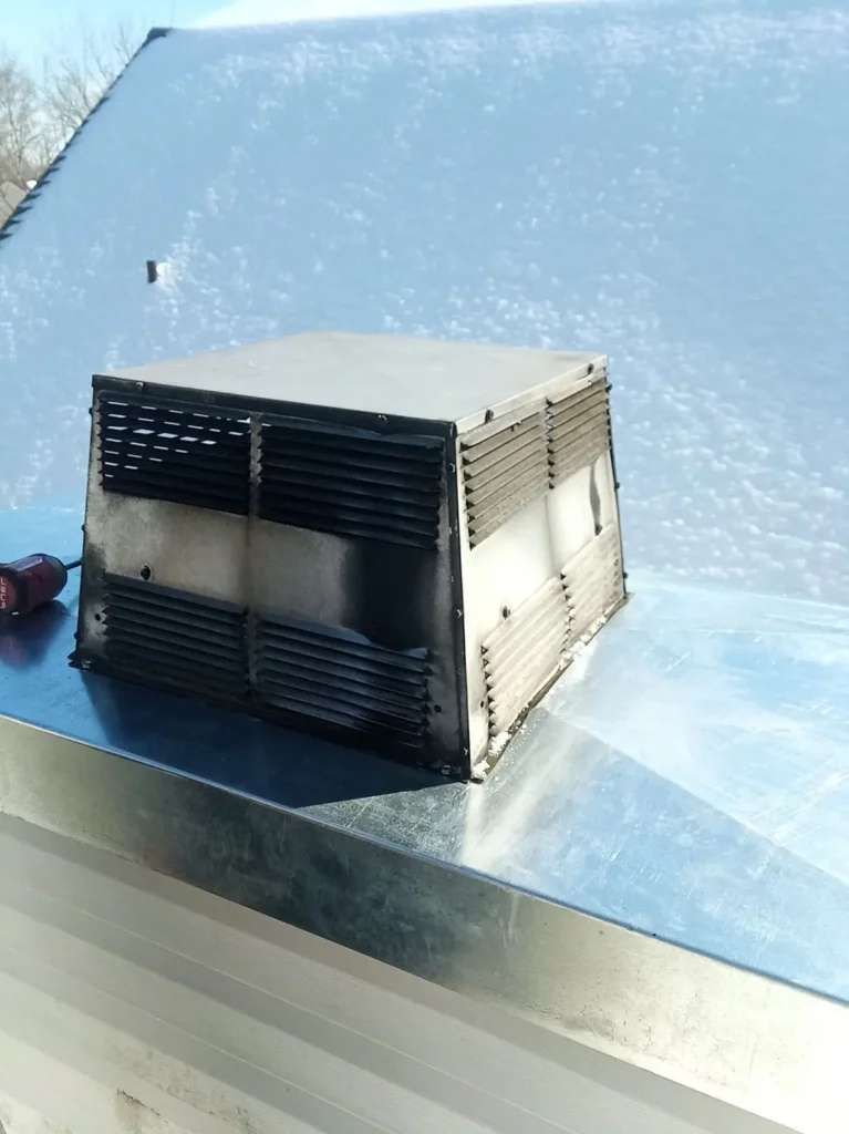 Metal chimney chase cover around a rooftop termination in Winslow Township