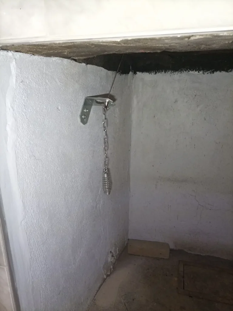 Damper operating bracket, chain and handle inside a Mount Laurel fireplace