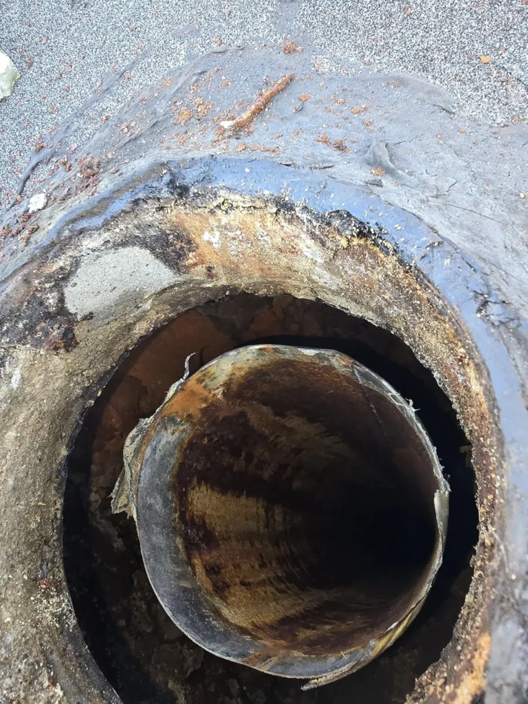 Close view of a metal flue opening and surrounding chimney surface in Bloomsbury