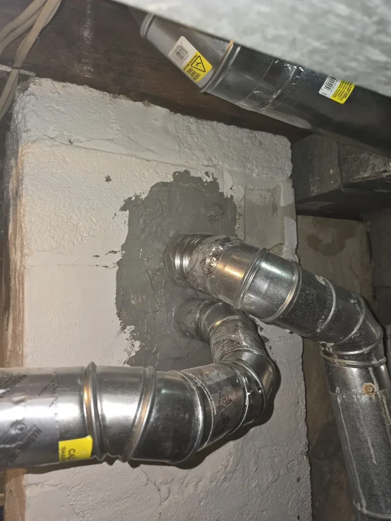 Two vent connections entering a chimney wall in Union