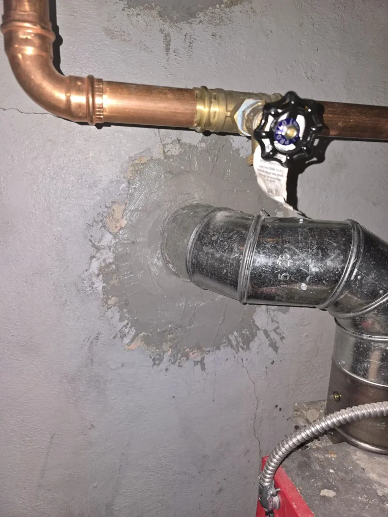 Close view of a heating vent connection at the chimney wall