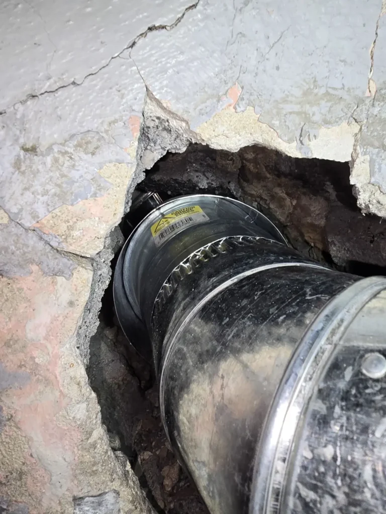 Heating vent connector at an open chimney wall penetration in Milltown